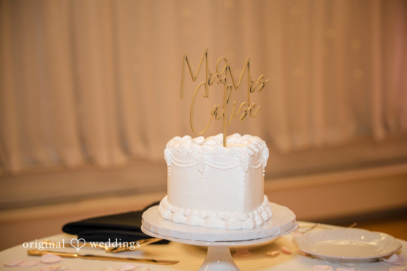 Emily + Angelo Small single-tier white wedding cake displayed on an elegant stand.