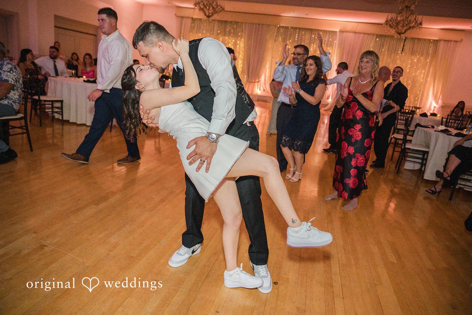 Emily + Angelo Groom lifting the bride into the air on a crowded dance floor.