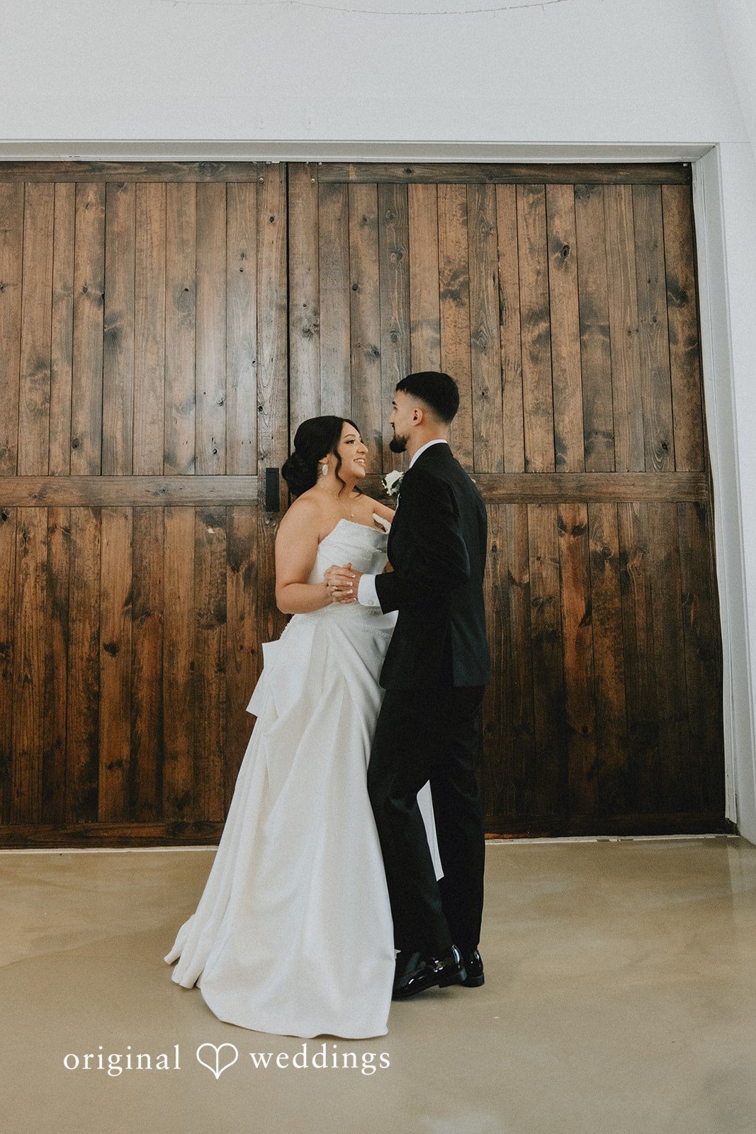 Briana + Joshua Couple kissing by the barn doors at Always Timeless Barn