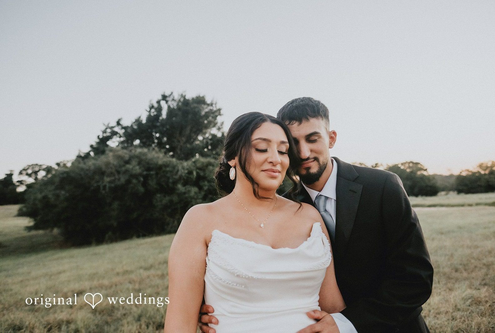 Couple close in the field, captured by Austin wedding photographers from Original Weddings at Always Timeless Barn