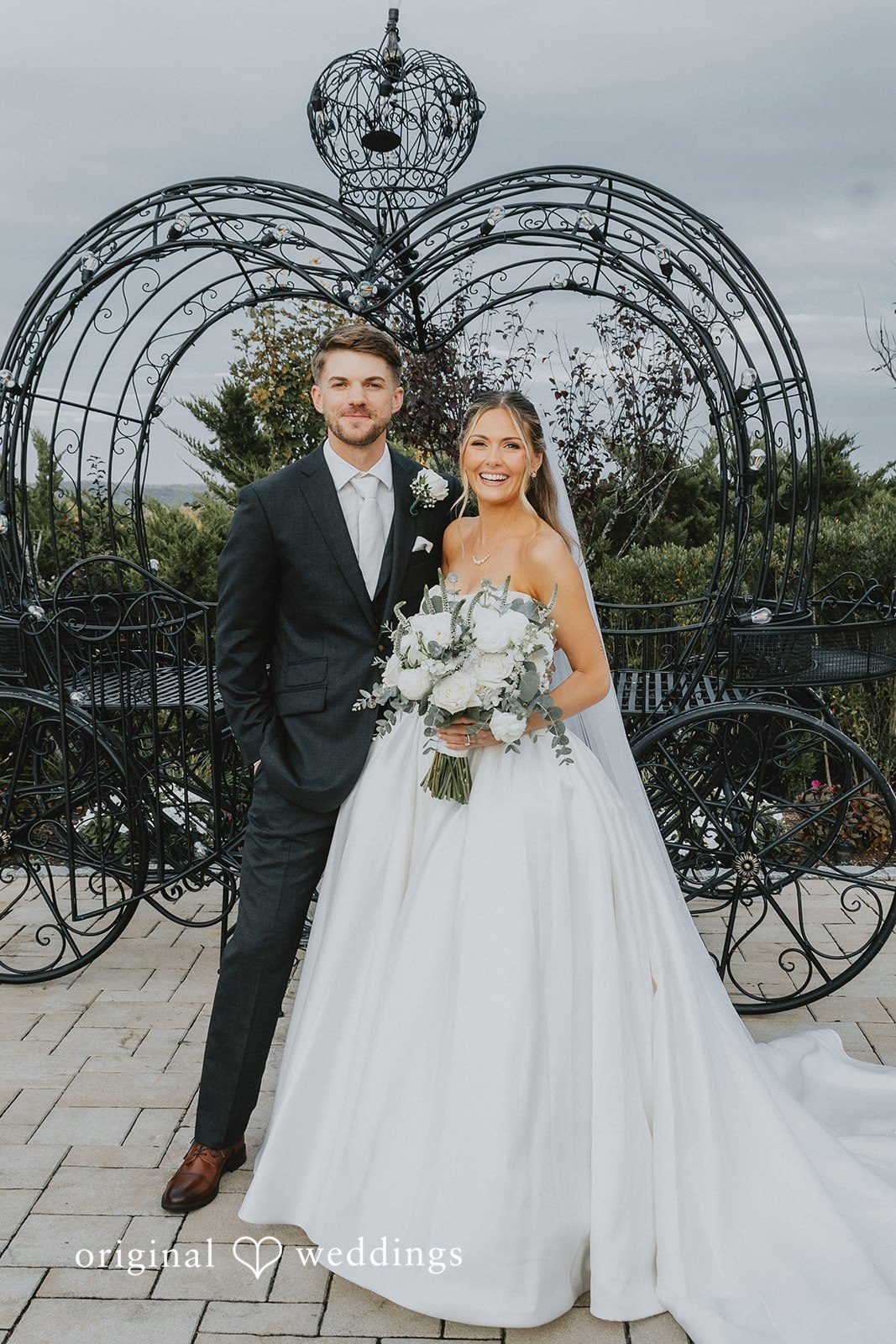 Emily + Max Emily and Max in front of the iron carriage arch, captured by Hartford wedding photographers from Original Weddings at Aria Wedding and Banquet Facility