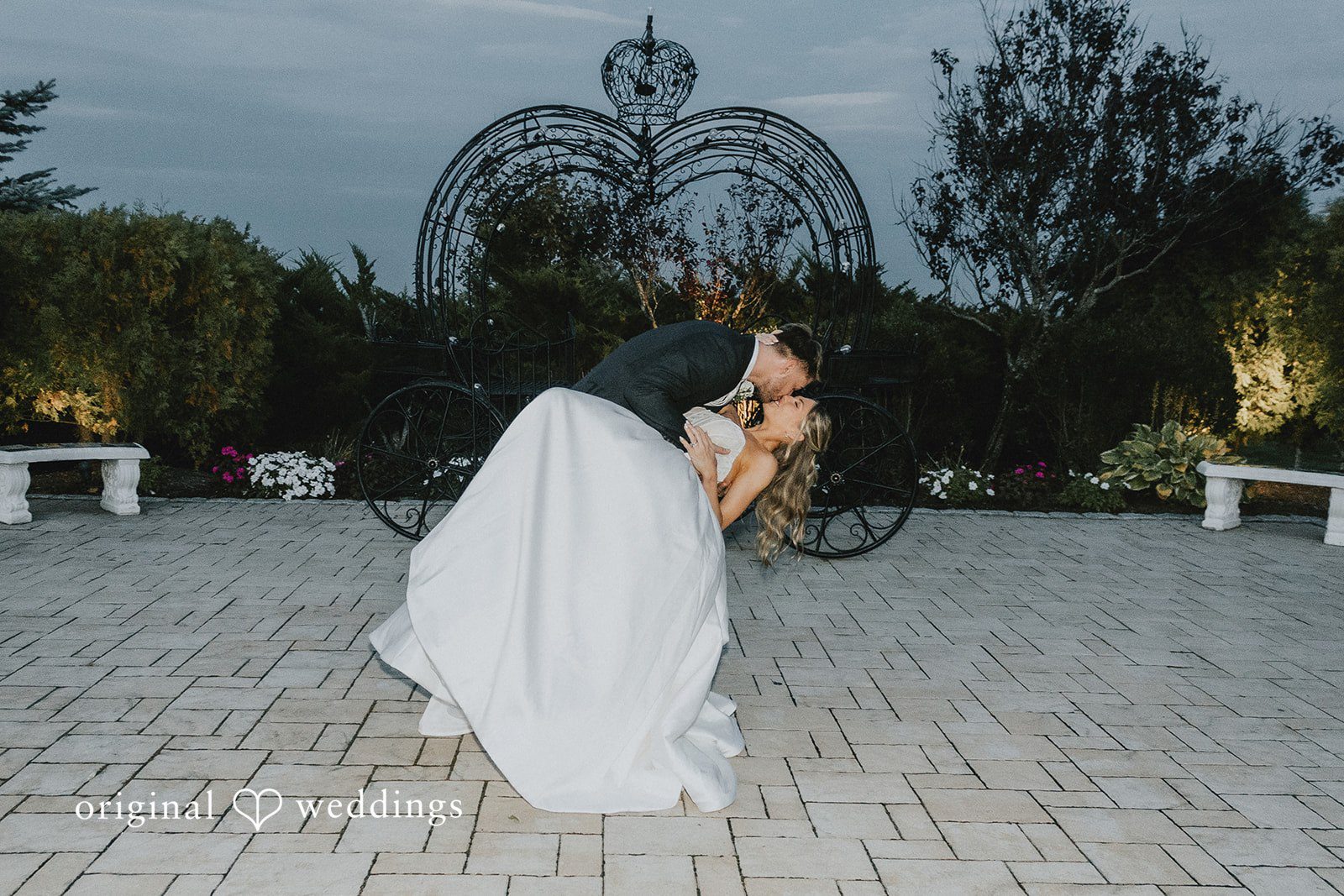 Emily + Max Evening dip kiss in the courtyard at Aria Wedding and Banquet Facility