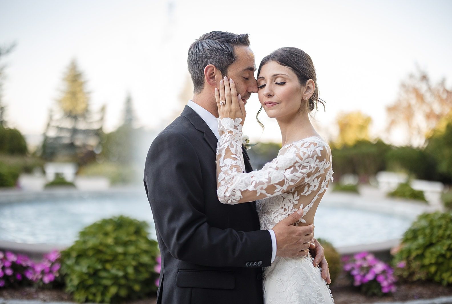 Christina and Anthony embracing by the fountain, captured by Hartford wedding photographers from Original Weddings at Aria Wedding and Banquet Facility
