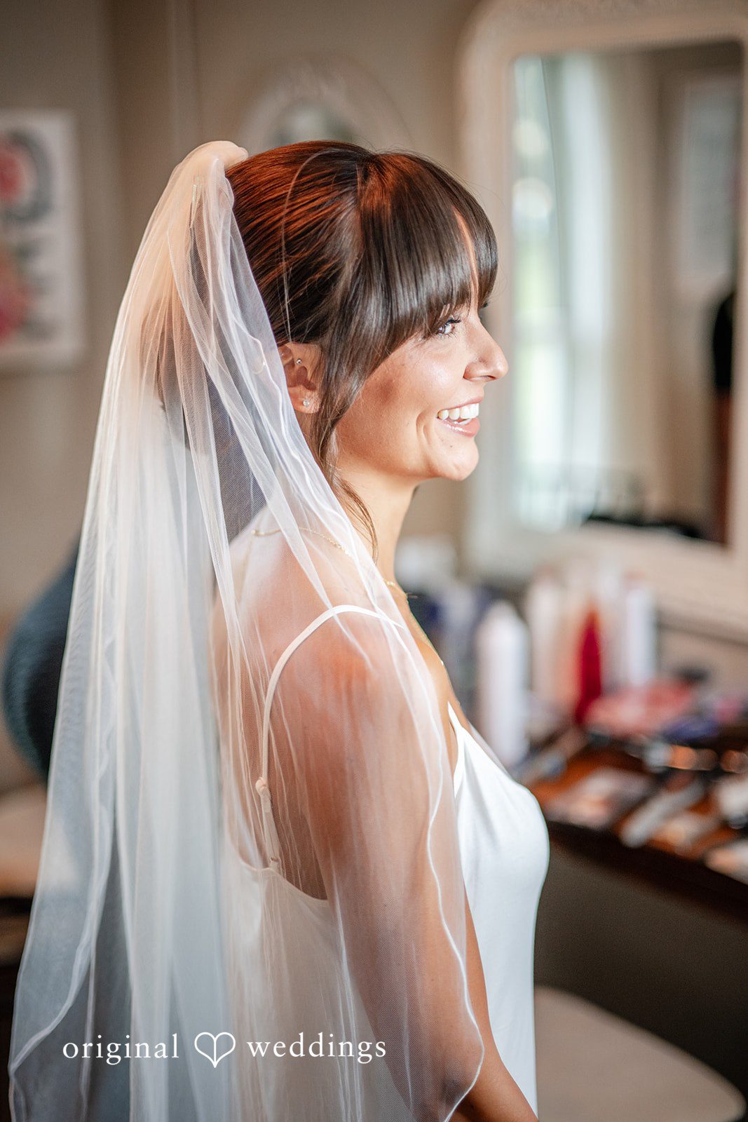 Bride adjusting her veil while getting ready