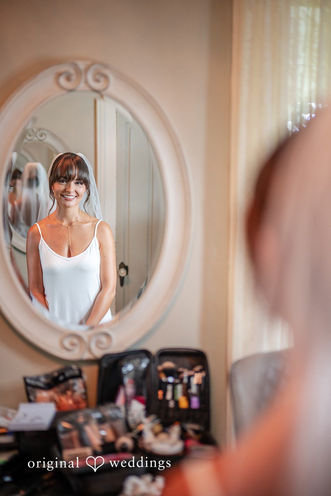 Bride getting ready in front of a round mirror