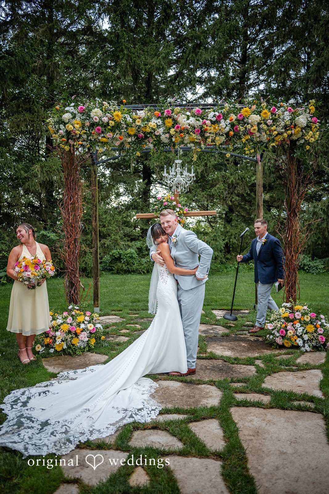 Couple standing under the floral arch at Ashley Farm