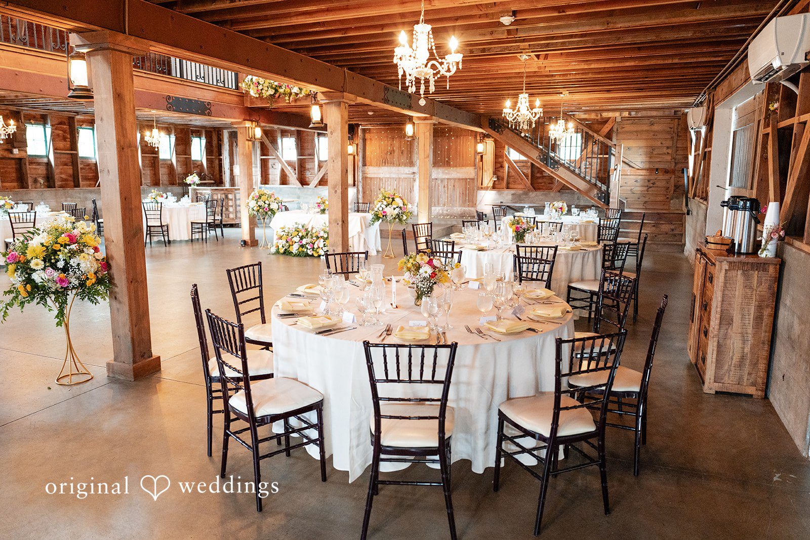 Reception tables set up inside the barn at Ashley Farm