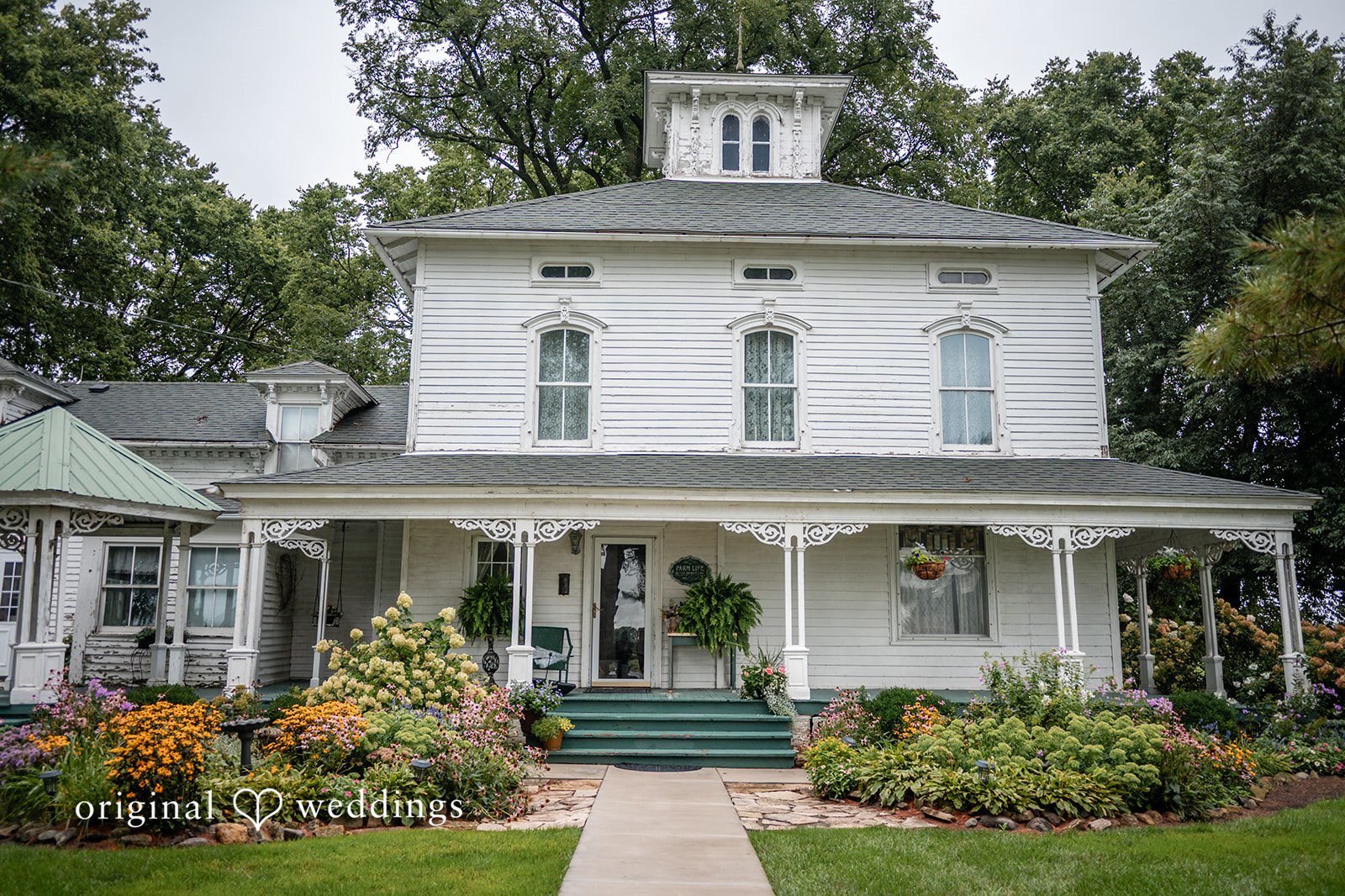 White farmhouse surrounded by gardens at Ashley Farm