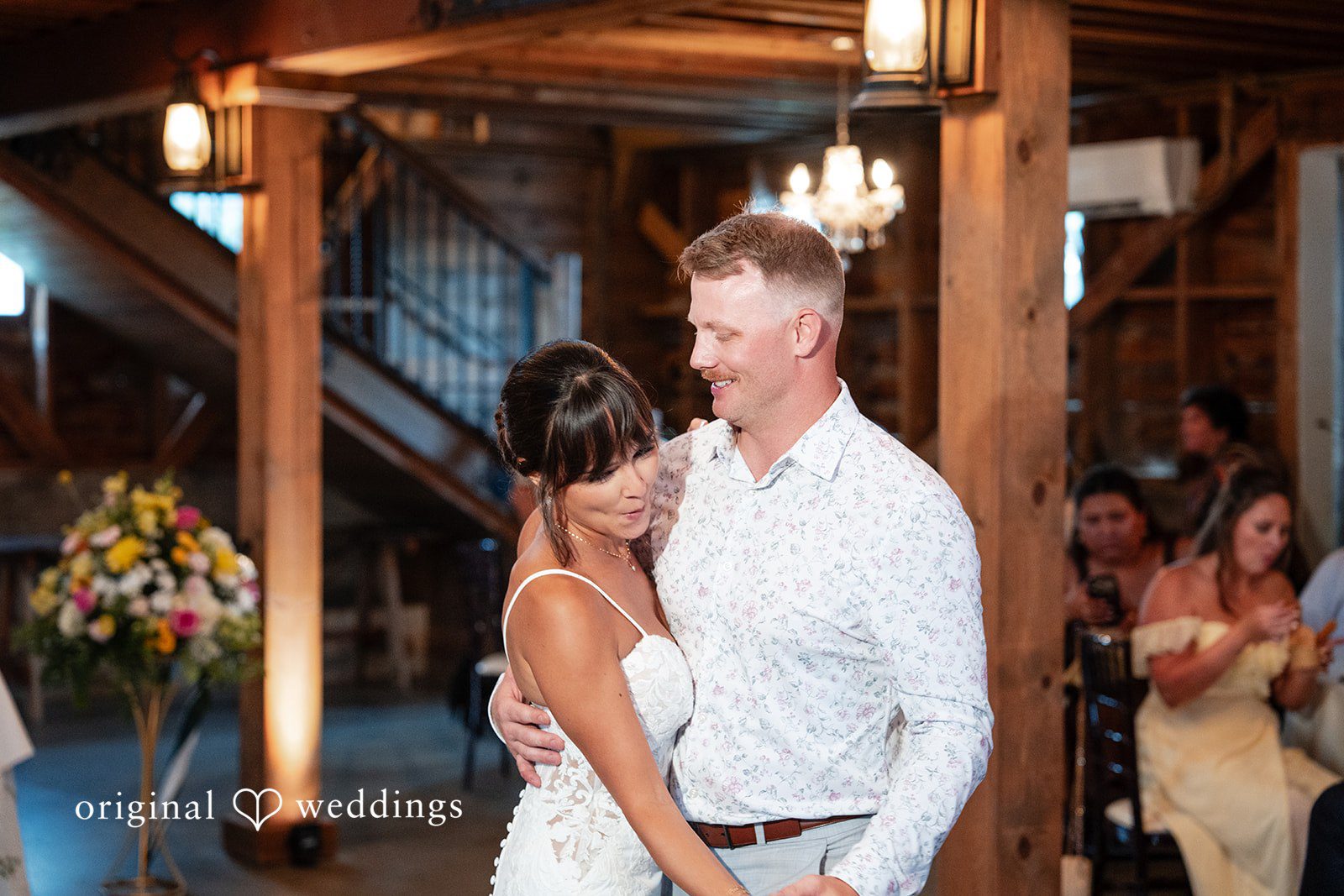 Couple dancing with guests in the barn