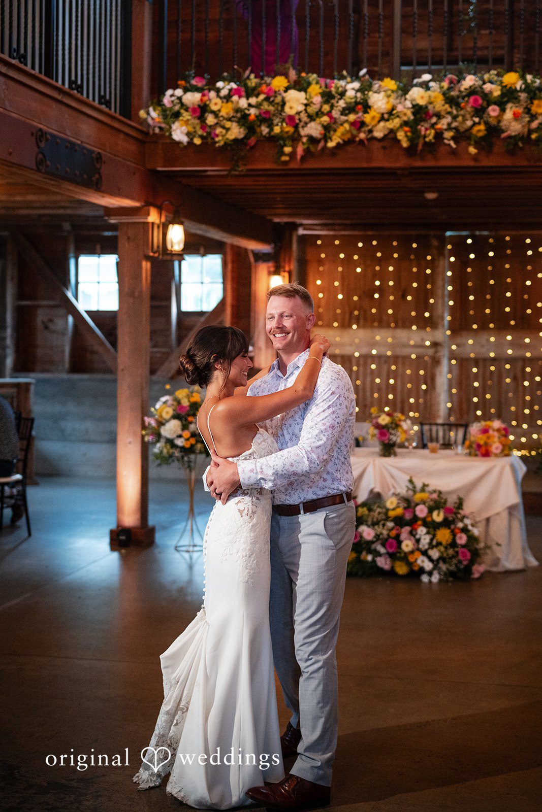 Couple dancing beneath the barn lights