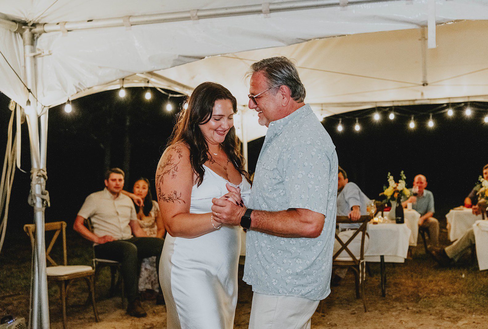 Bride and groom dancing under the tent lights, captured by Austin wedding photographers from Original Weddings at their Texas backyard wedding