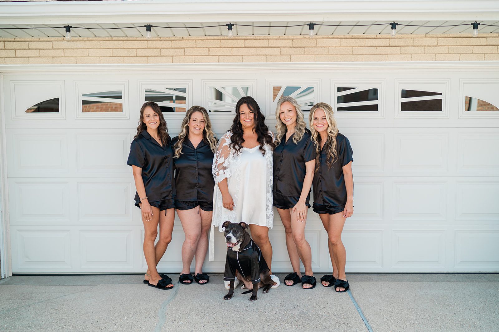 Bridesmaids in black robes with the family dog