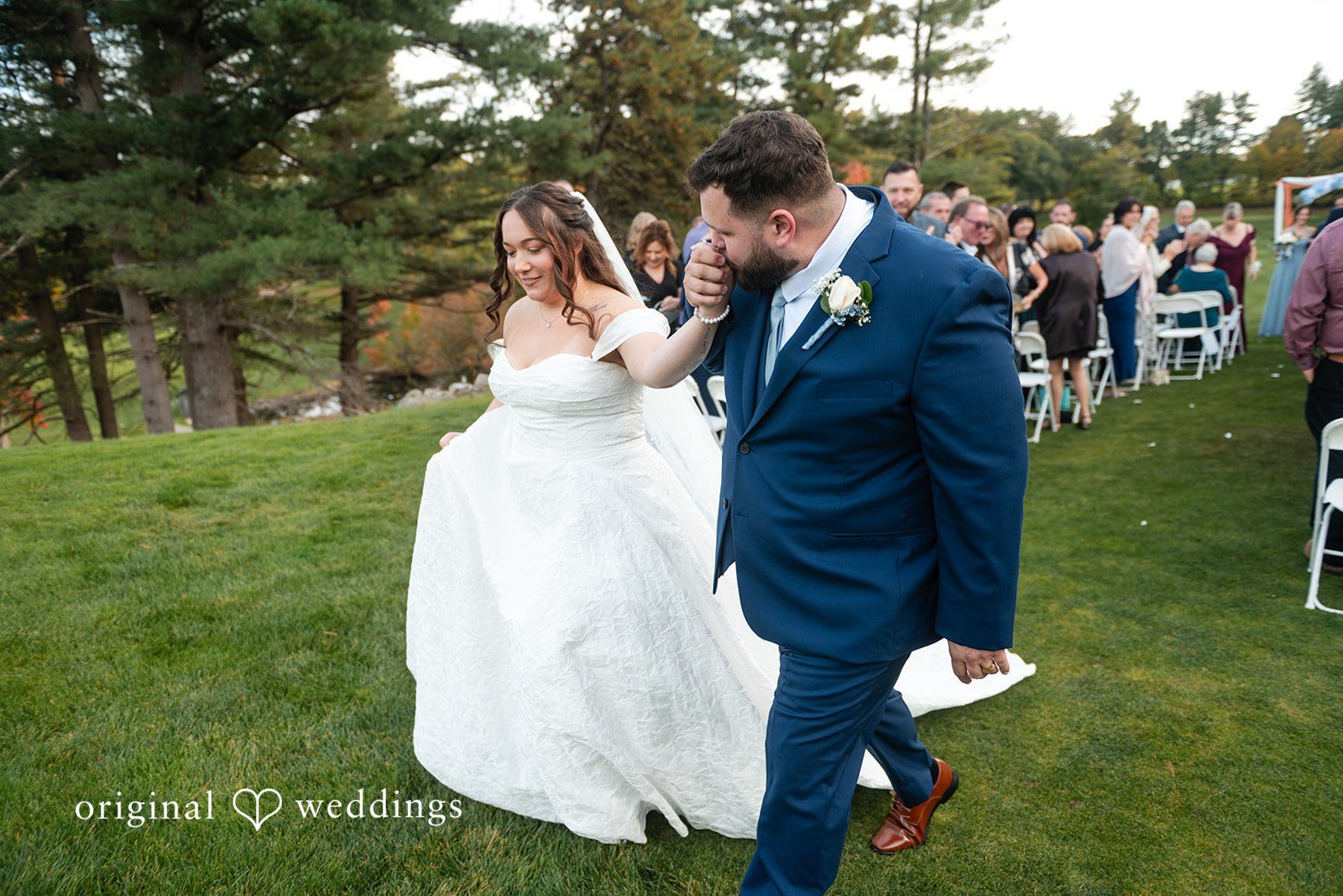 Bride and groom walking across the lawn