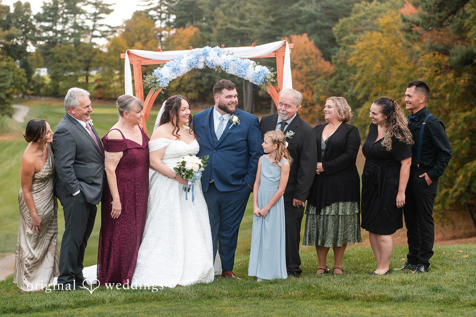 Family photo with the couple at the ceremony arch
