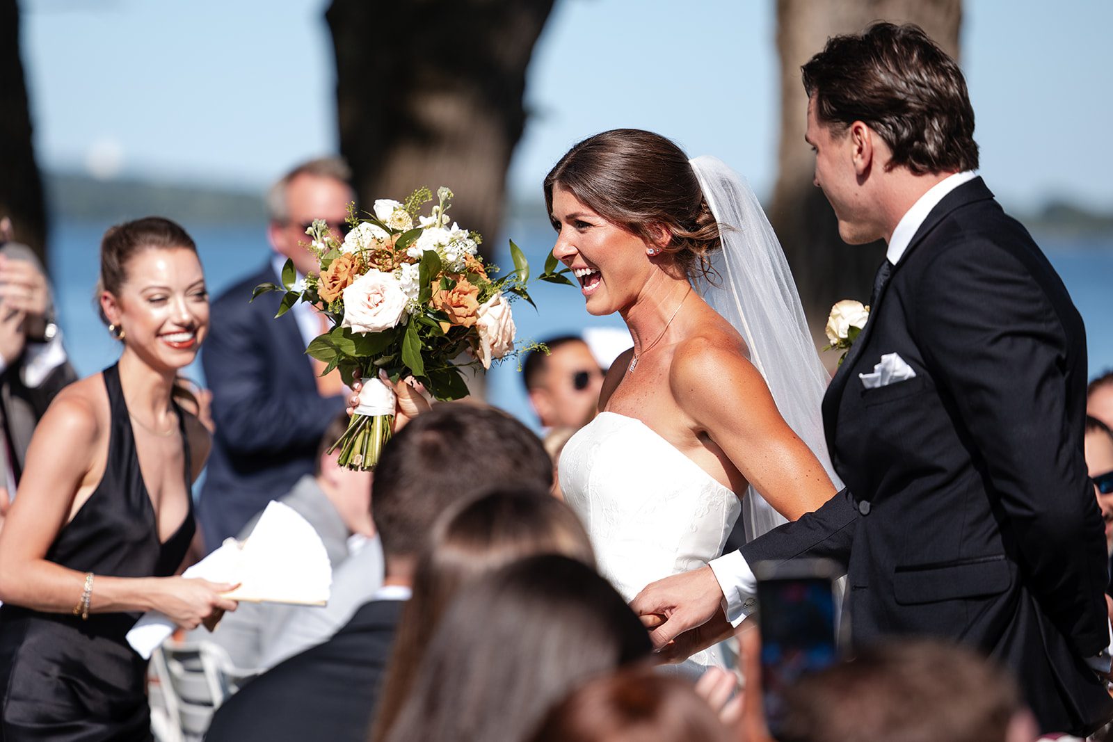 bishops-bay-country-club-timeless-madison-bianca-colin-p024-01 Guests cheering as the newlyweds walk by