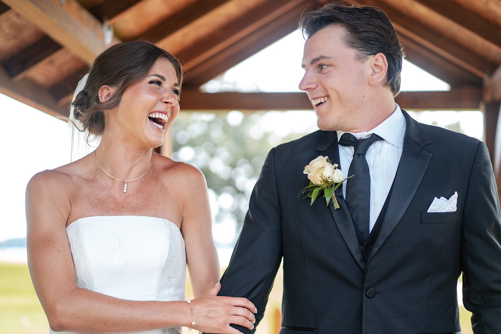 bishops-bay-country-club-timeless-madison-bianca-colin-p030-13 Bride and groom laughing together under the pergola, captured by Madison wedding photographers from Original Weddings at Bishops Bay Country Club