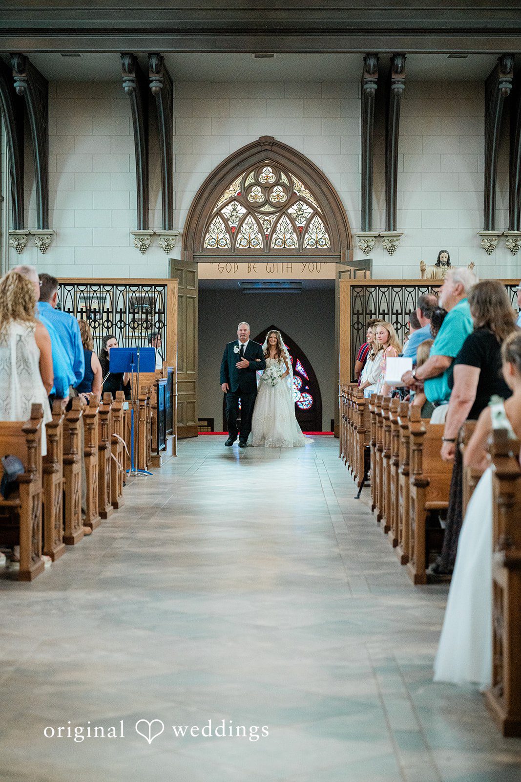 The bride's father escorts the bride down the aisle
