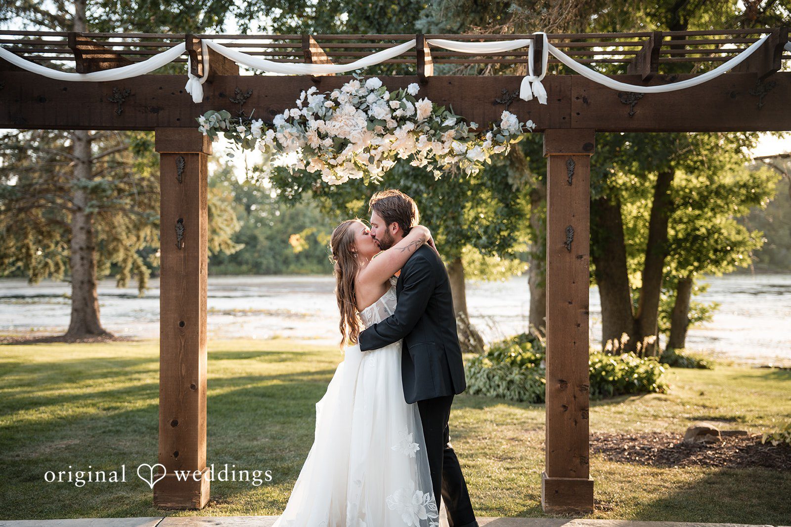 First kiss under the arch at Brianos Charthouse Lakeville