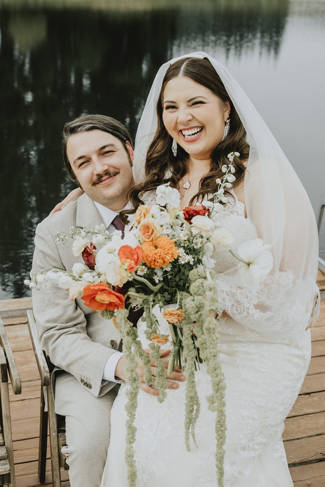 Bride and groom smiling together on the dock, captured by Portland wedding photographers from Original Weddings at Brightwater Weddings & Events