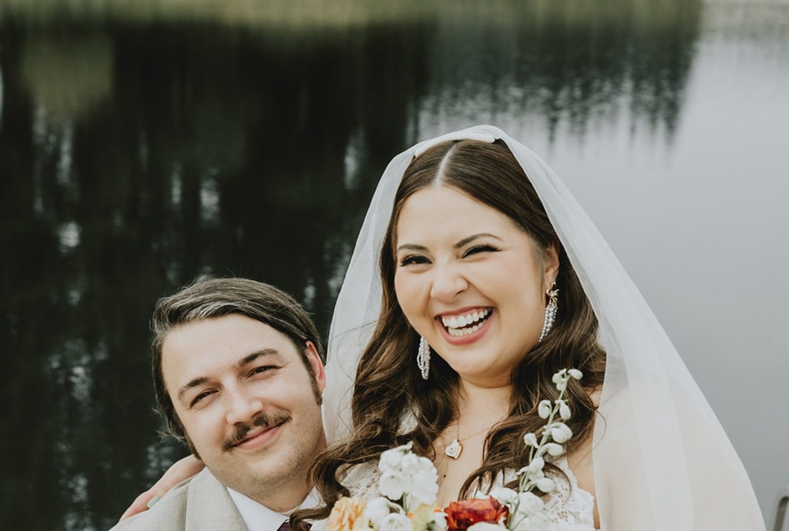 Bride and groom smiling together on the dock, captured by Portland wedding photographers from Original Weddings at Brightwater Weddings & Events