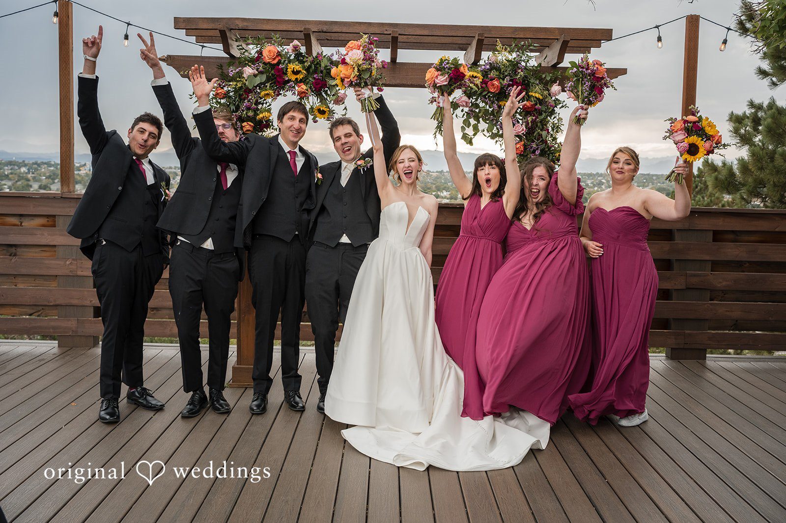 Our Denver wedding photographers at Original Weddings captured a joyful portrait of the couple and their bridal party at Brittany Hill