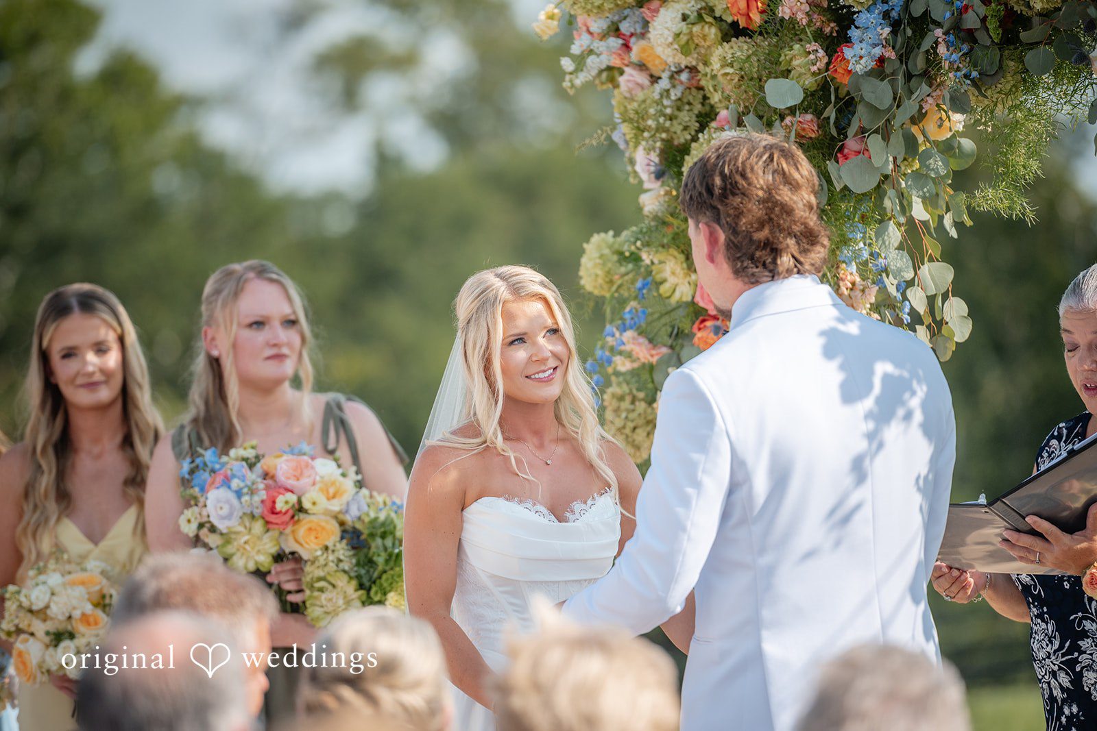 Bridesmaids smiling during the outdoor ceremony