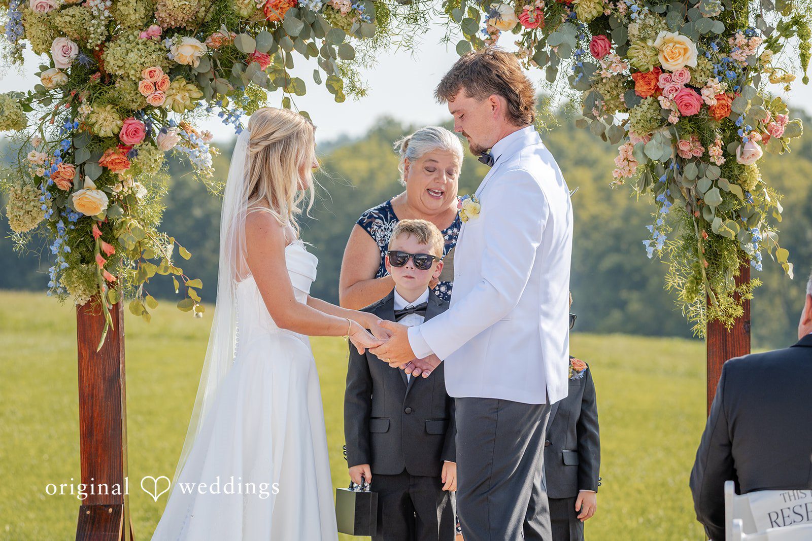 Couple exchanging vows at the floral arch