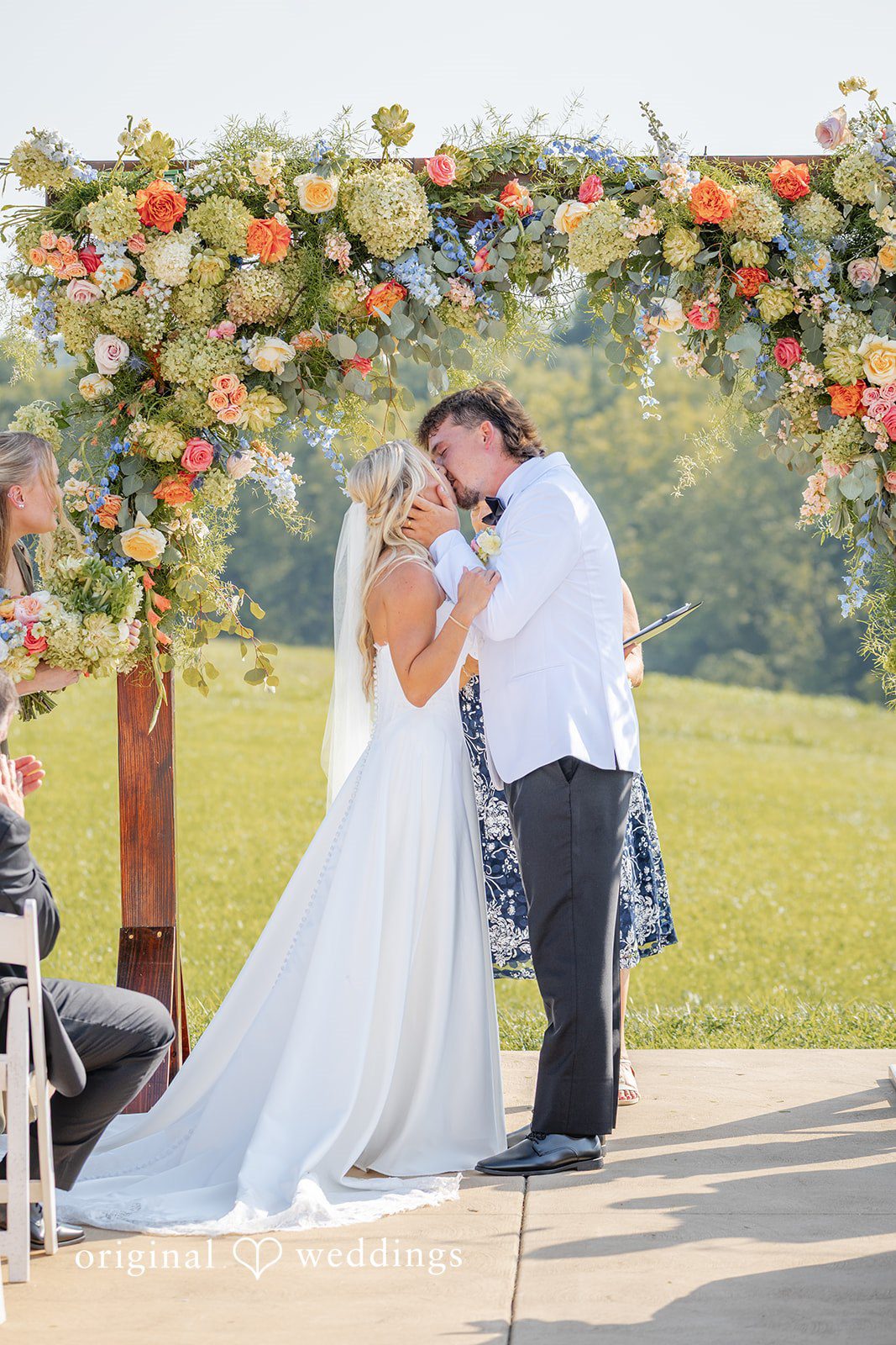 Couple posing at the floral arch at Bryton Barn