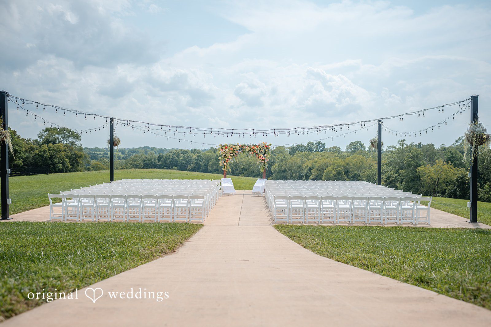 Ceremony site with white chairs on the lawn at Bryton Barn