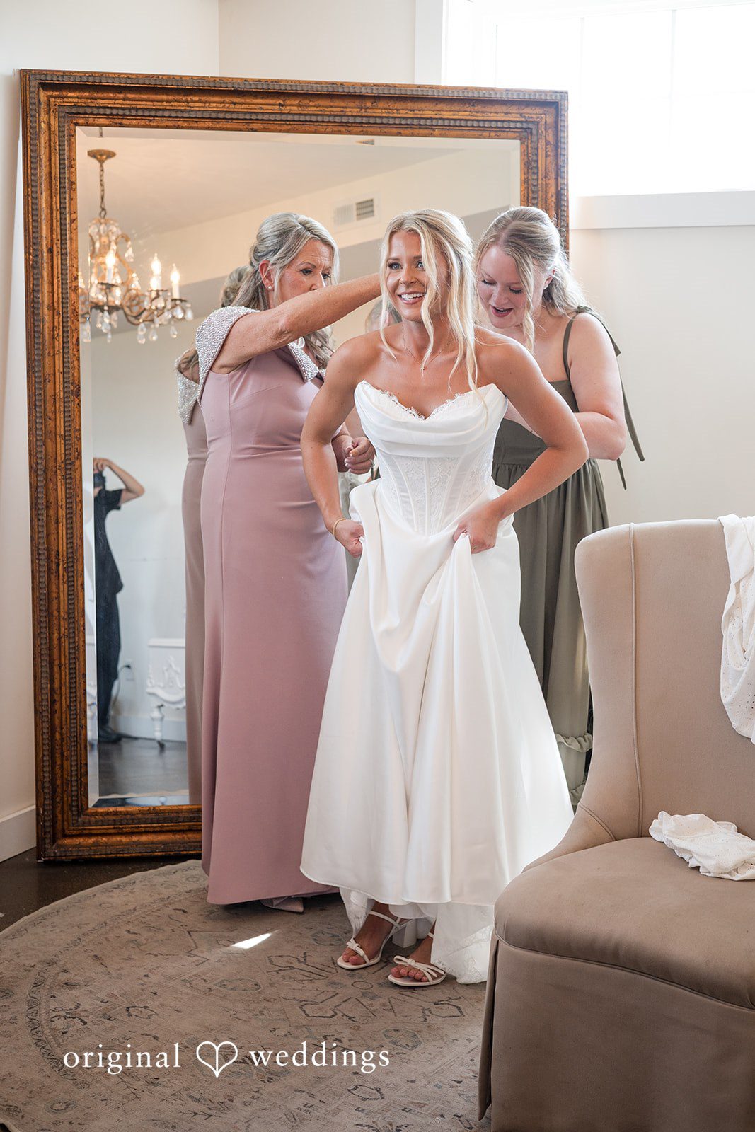 Bride getting ready with a bridesmaid at the mirror