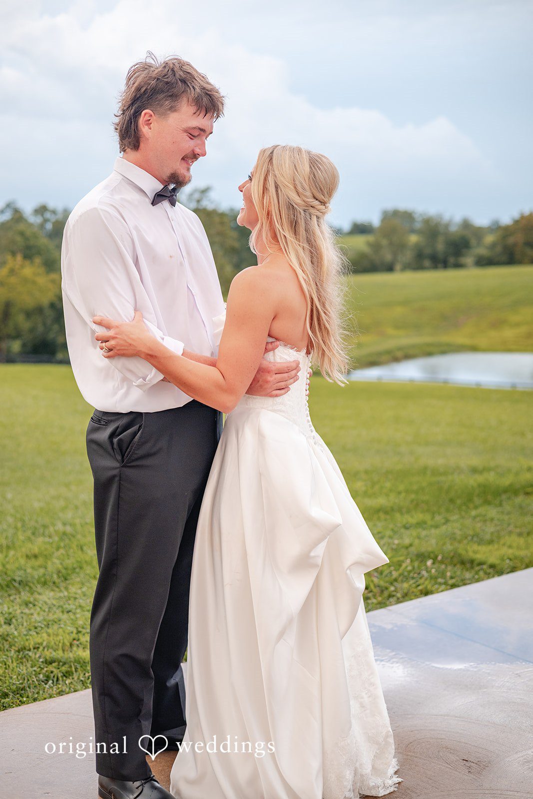 Bride and groom standing close on the lawn