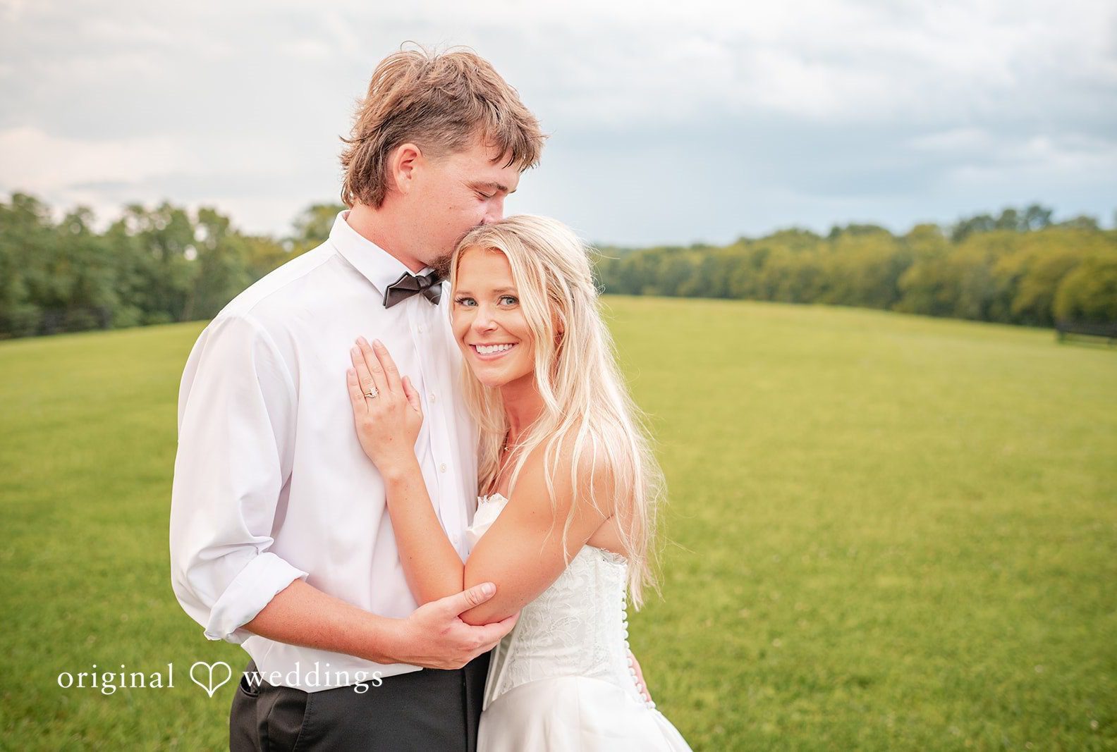 Bride and groom embracing on the open lawn, captured by Cincinnati wedding photographers from Original Weddings at Bryton Barn