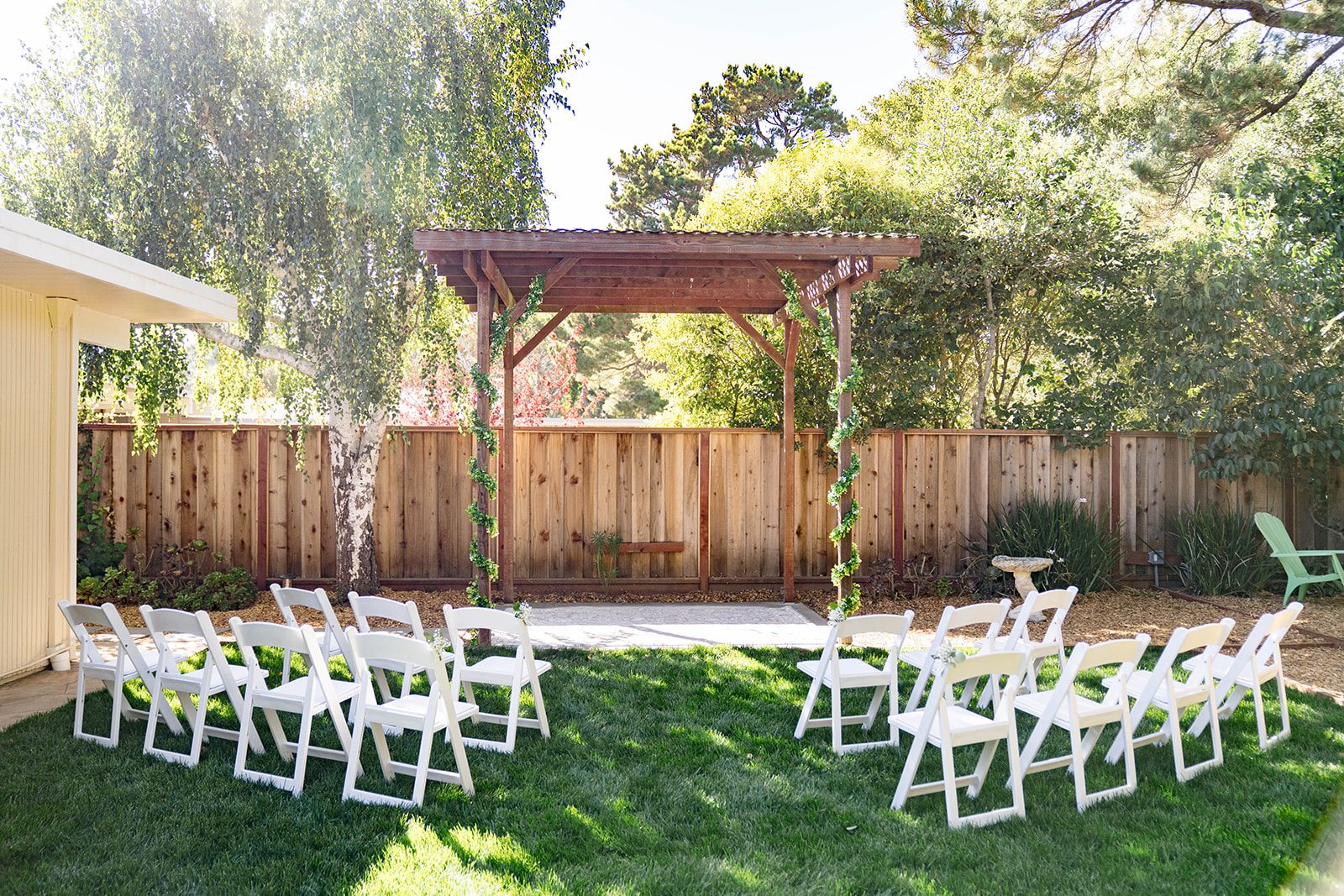 Backyard ceremony setup under the trees at a California backyard wedding