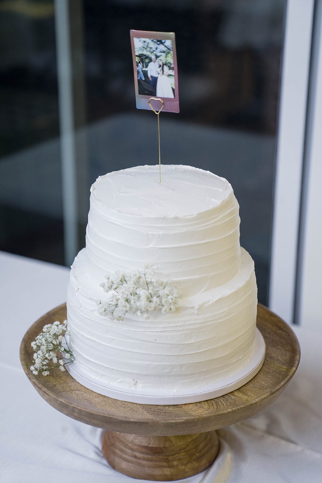 White wedding cake on a gold stand