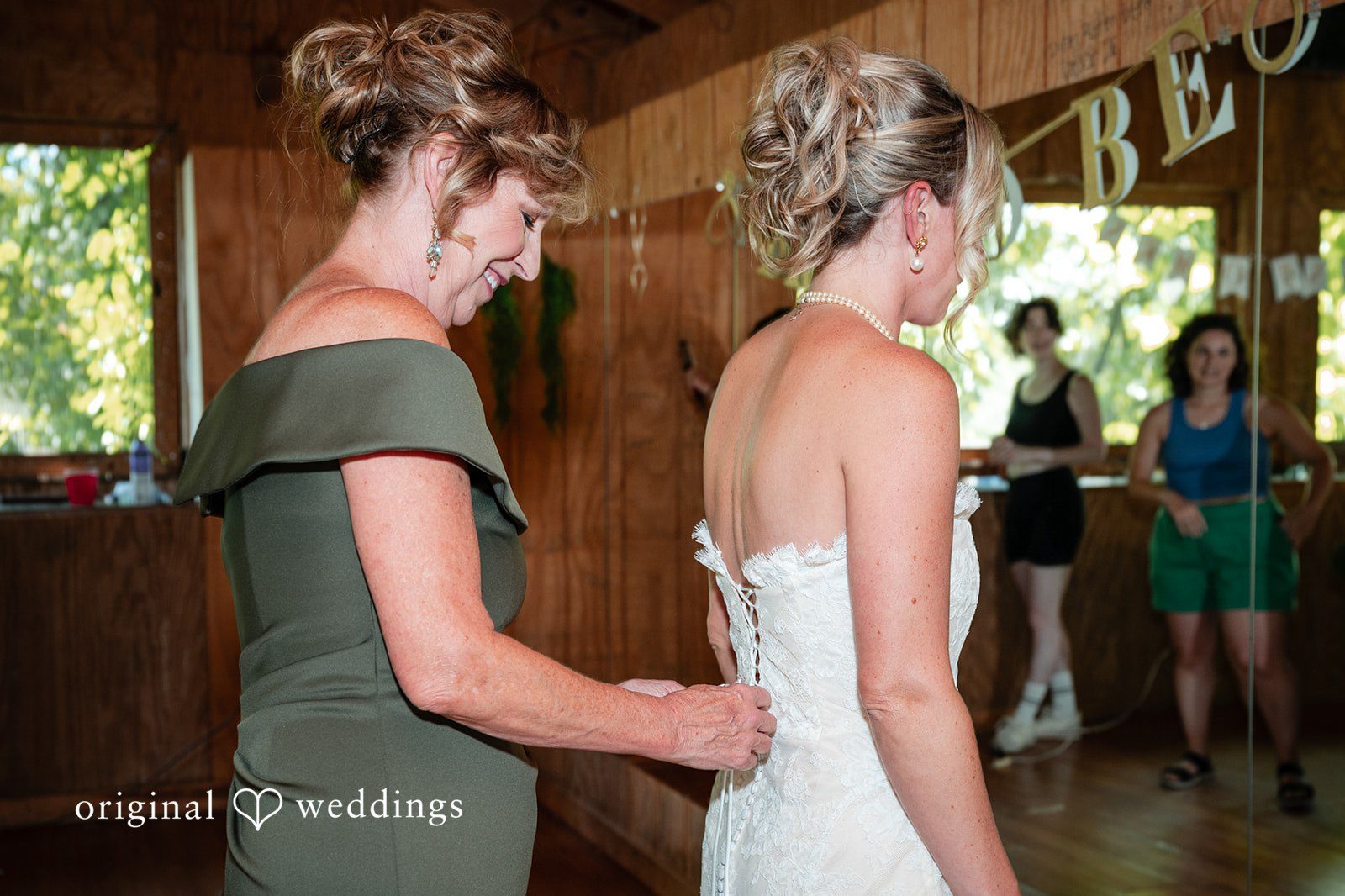 Bridesmaid helping the bride get dressed