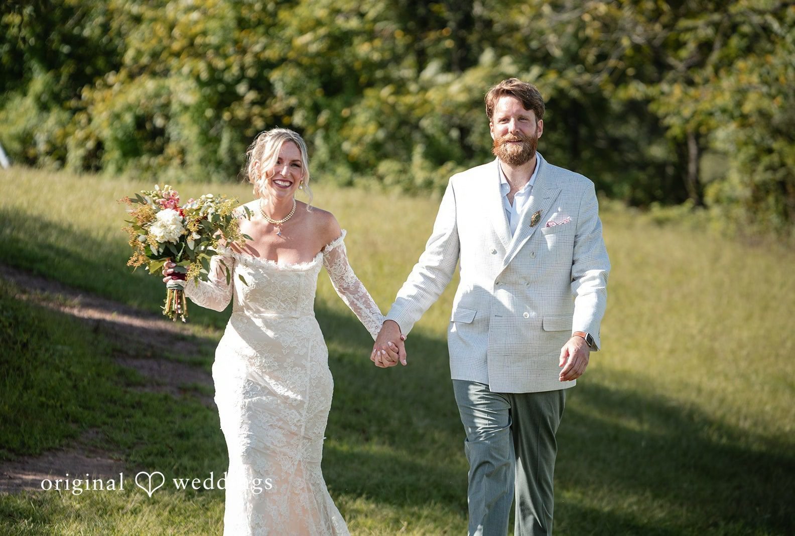 Couple walking hand in hand in the field, captured by Philadelphia wedding photographers from Original Weddings at Camp Kweebec