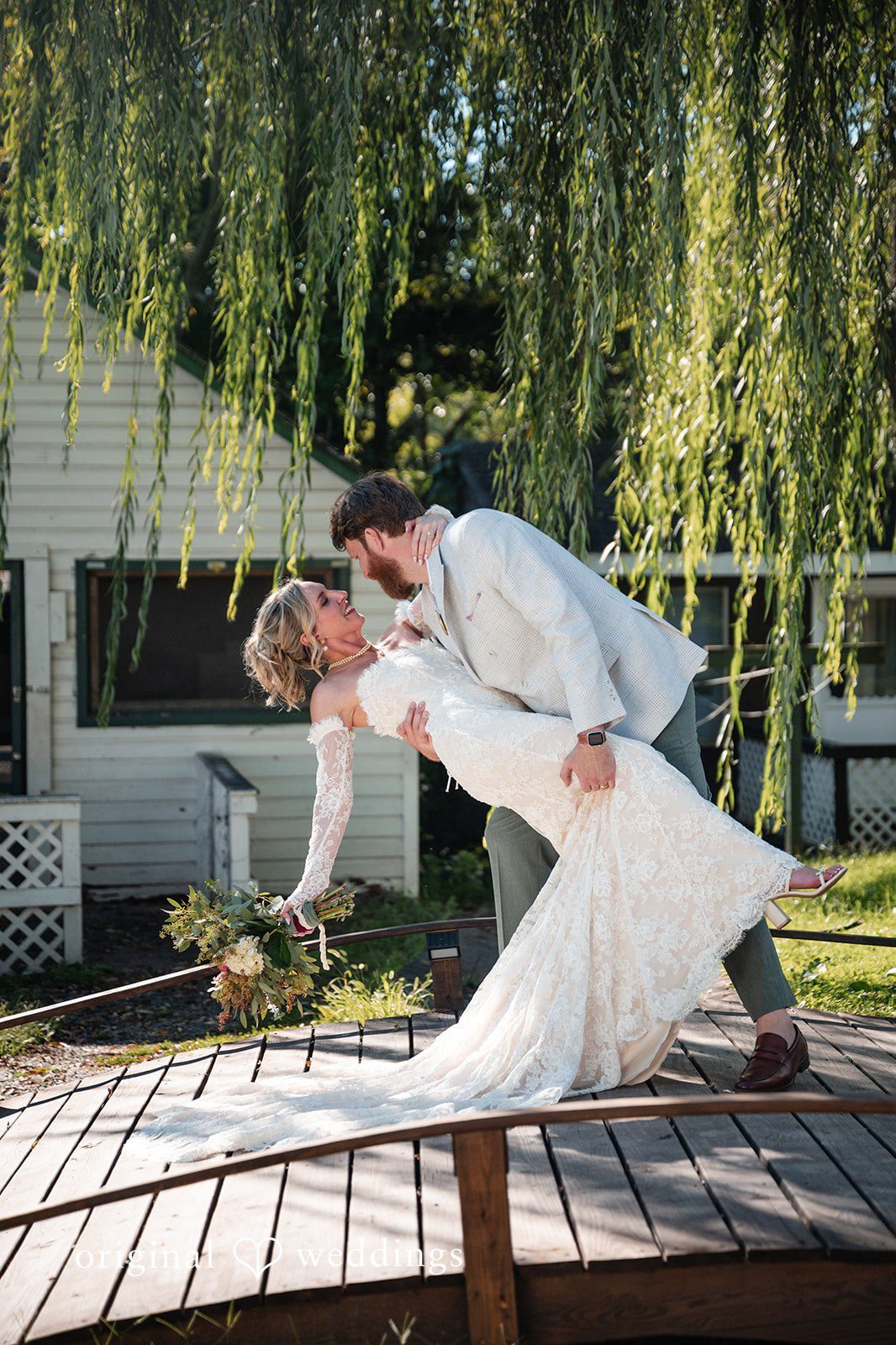 Groom dipping the bride on the bridge