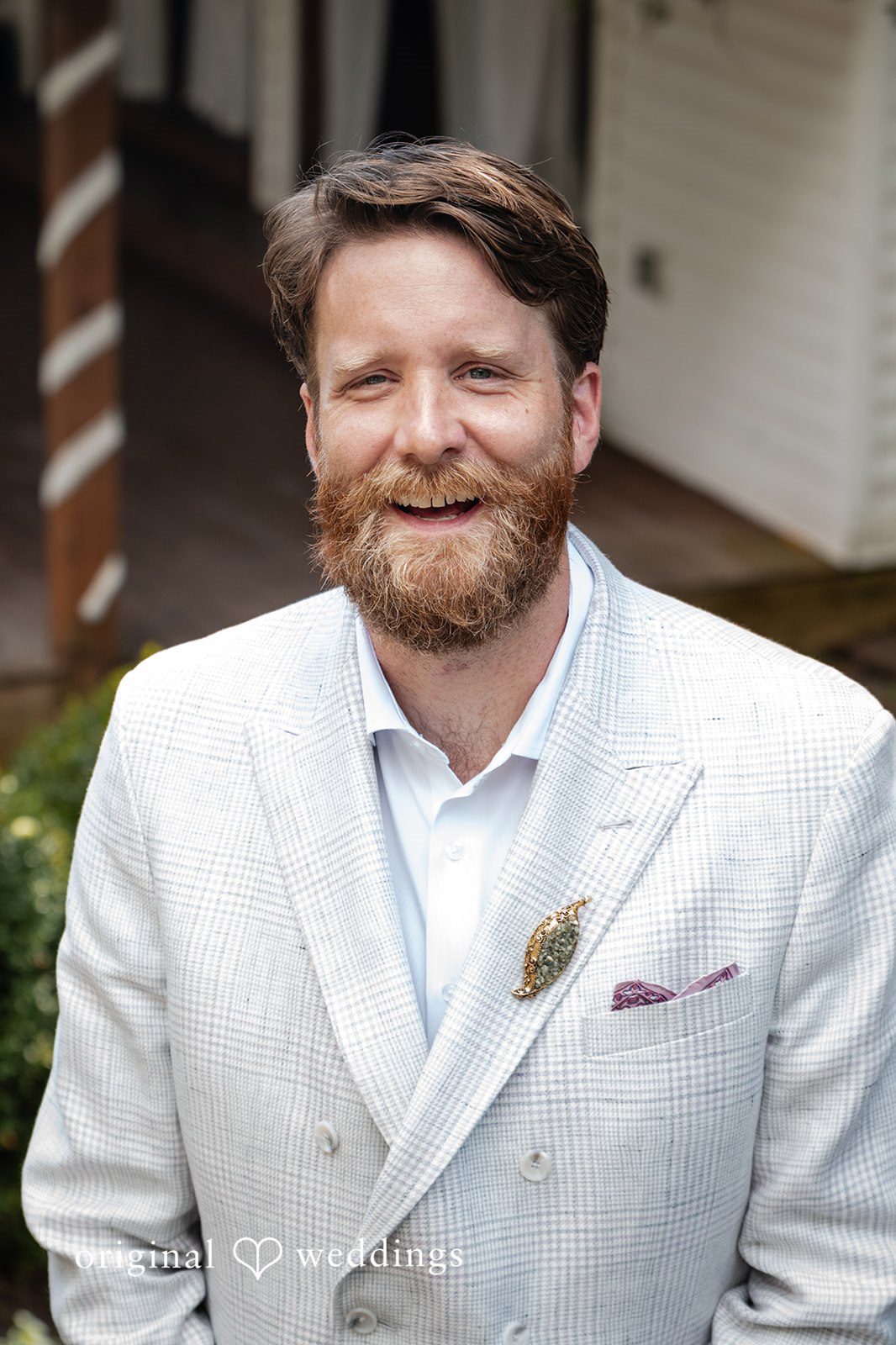 Groom smiling in a white jacket at Camp Kweebec