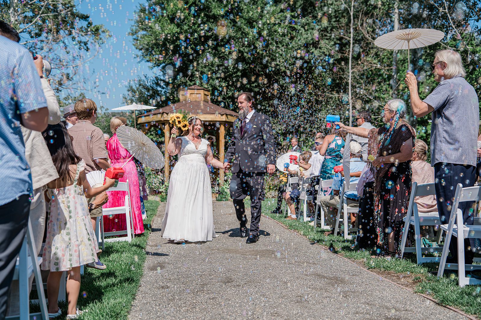 chatfield-farms-airy-denver-june-logan-013-32 Guests cheering as the couple walks back up the aisle