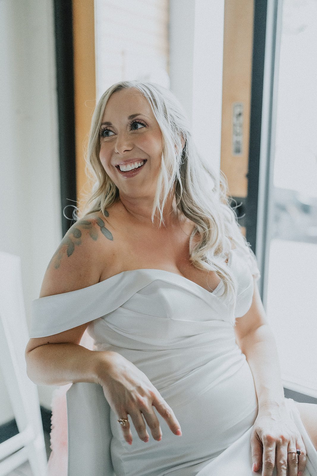 Bride smiling in her off the shoulder gown