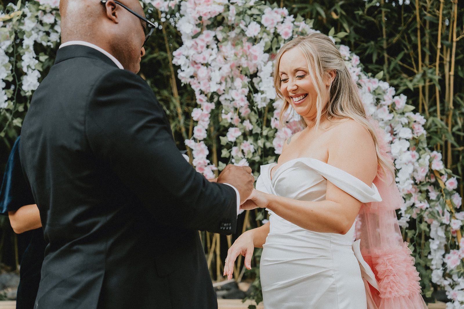 Couple sharing vows beside the wisteria arch