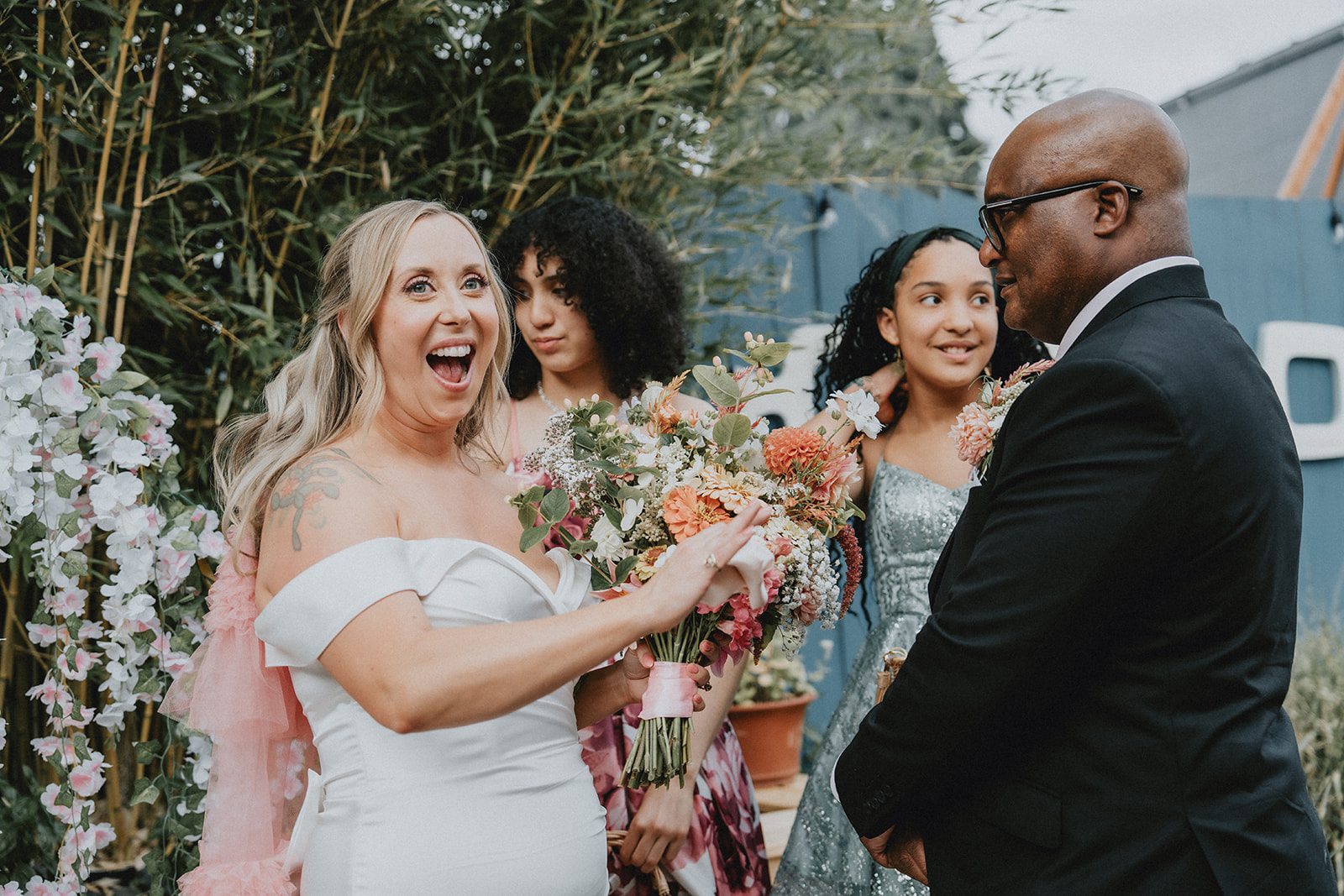 Bride laughing with guests and the groom