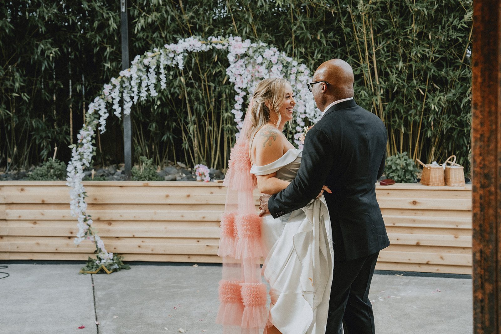 Couple dancing under the floral arch