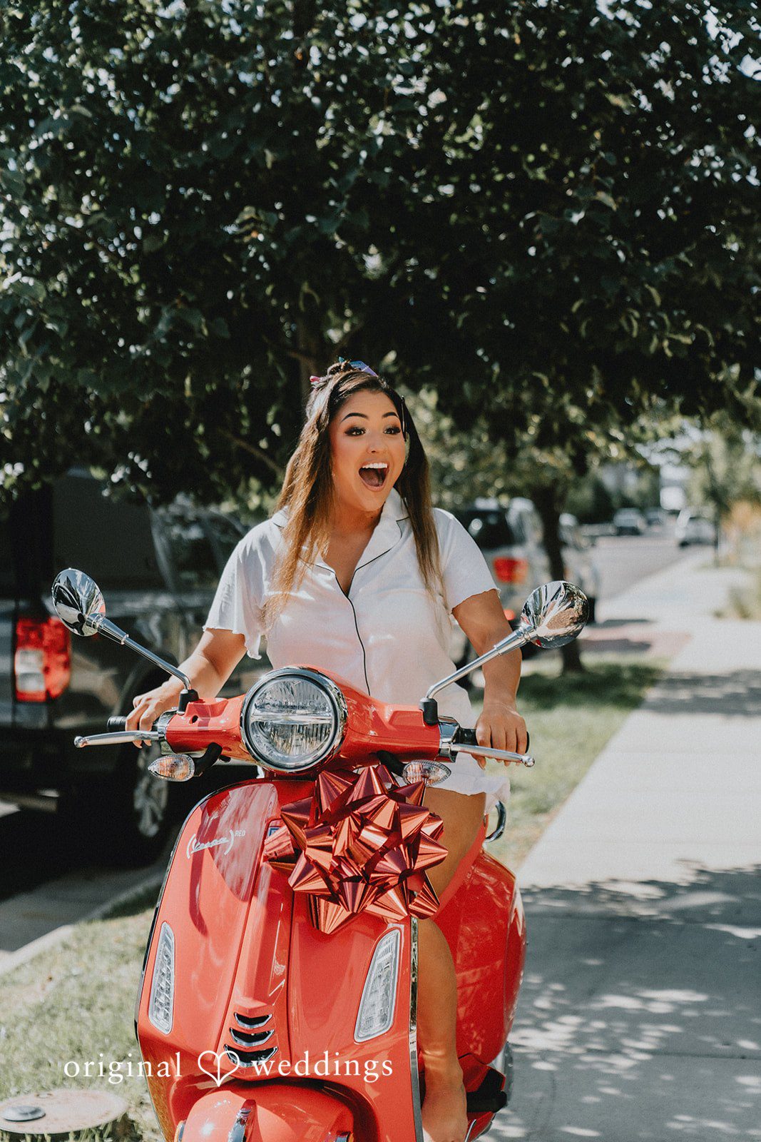 Sonia + Michael Bride riding a red scooter in her wedding dress