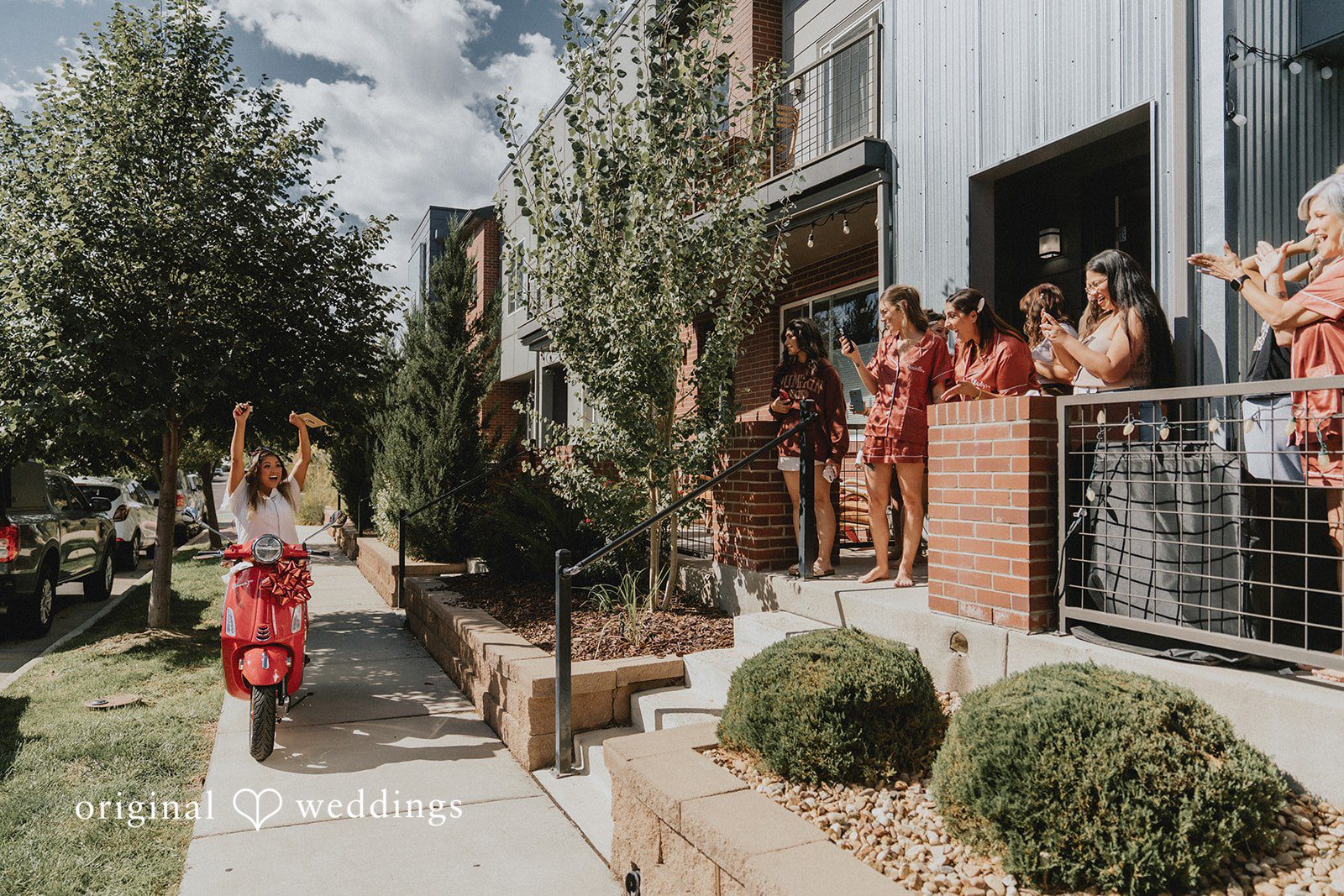 Sonia + Michael Bridesmaids cheering as the bride arrives on a red scooter