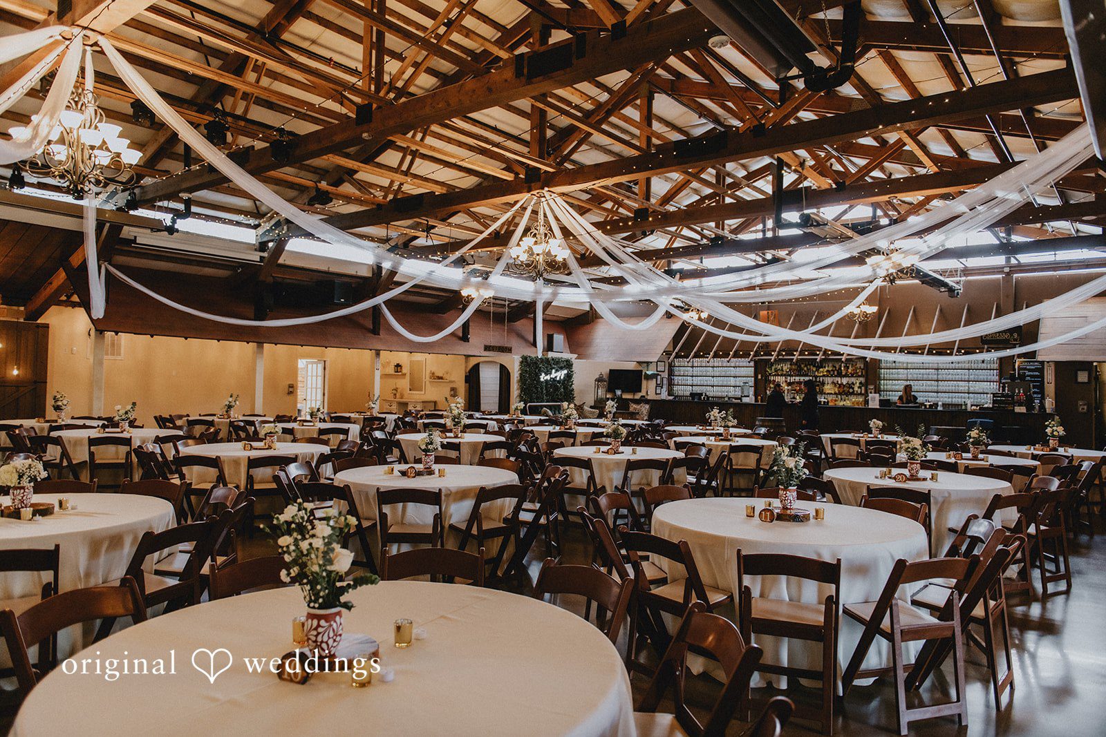 Sonia + Michael Rustic reception space with wood beams and string lights, captured by Denver wedding photographers from Original Weddings at Church Ranch Event Center