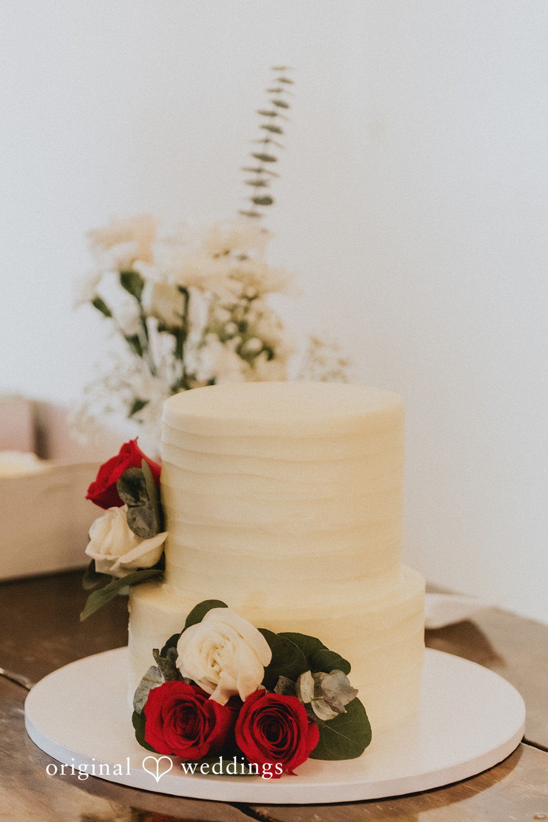 Sonia + Michael White wedding cake with red roses at Church Ranch Event Center