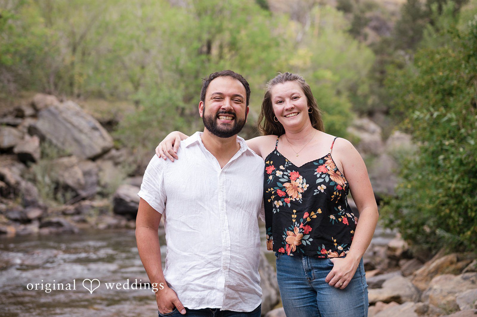 Theodore + Kathryn A smiling man in a white shirt and a woman in a floral top standing closely together.
