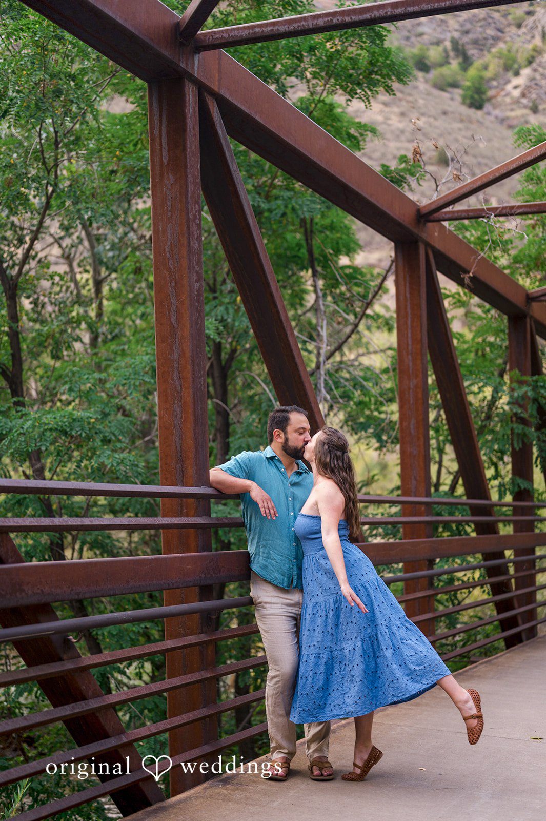 Theodore + Kathryn Couple posing together on a rustic wooden bridge.