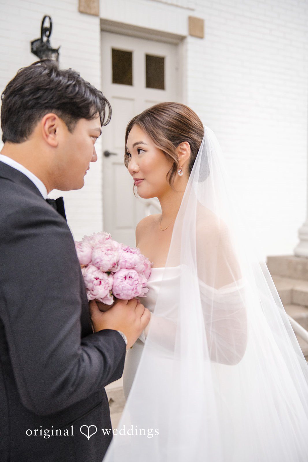 Yuri + Zachary Couple posing with her bouquet, captured by Atlanta wedding photographers from Original Weddings
